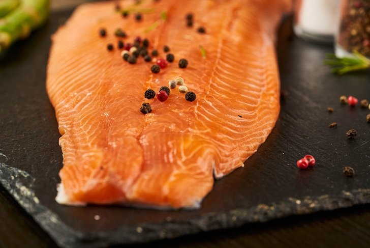 Salmon with black pepper on plate close up.