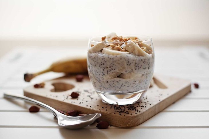 Banana chia yogurt pudding decorated with ripe sliced banana and peanuts