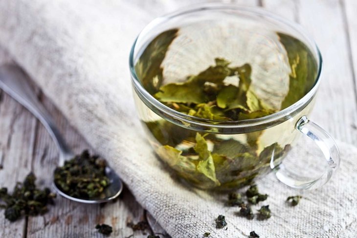 cup of green tea on rustic wooden table