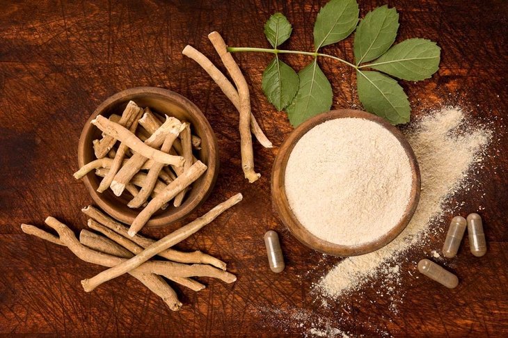 Ashwagandha superfood powder and root on cutting board on wooden table from above. Adaptogen.